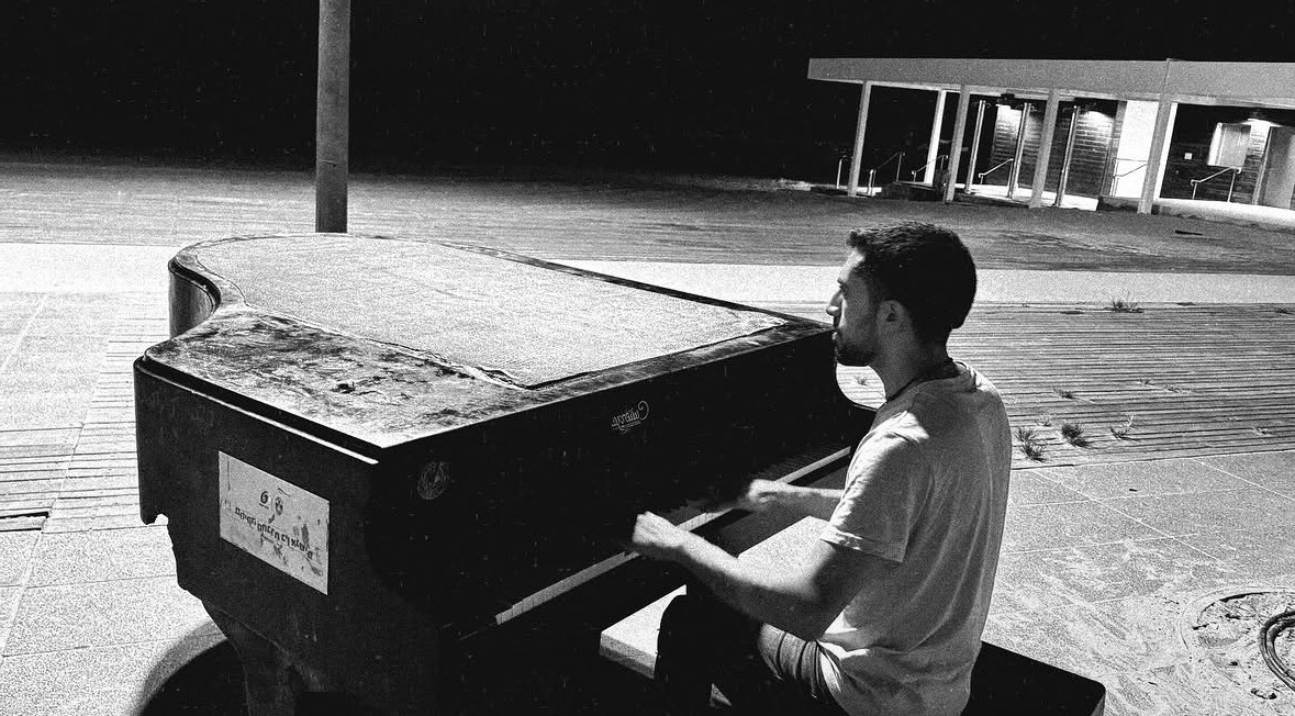 Yehuda playing a street piano at night